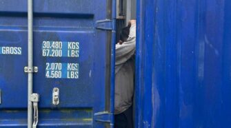 hombre atrapado entre contenedores